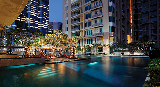 Link to deluxe condominium Marriott Vacation Club at The Empire Place in downtown Bangkok, shown at night at the pool