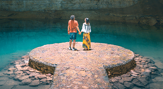 Couple exploring underground natural pool in Yucatán Peninsula of Mexico.